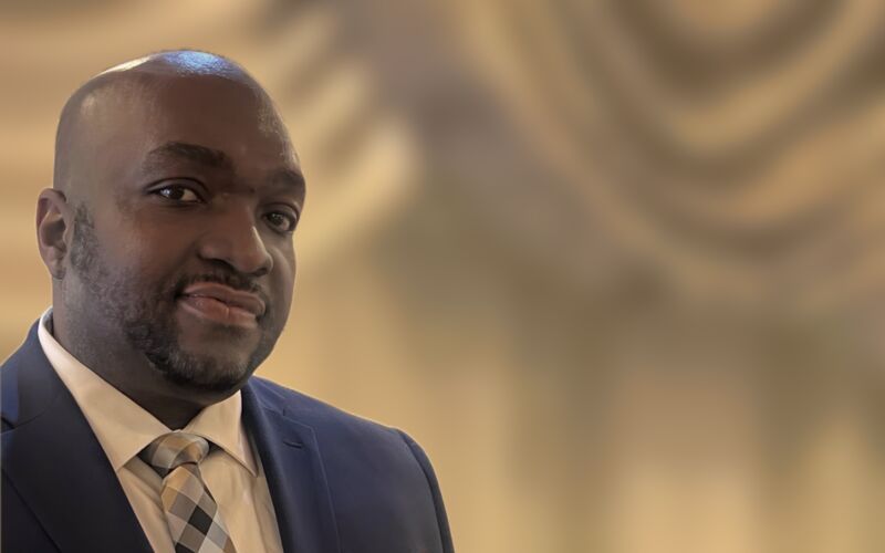 Yves Fabien, YEF Entertainment's MC, in a navy suit at a reception hall